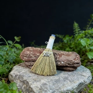 Macro detail of handmade Wicca broom with blue crystal and pentagram silver charm