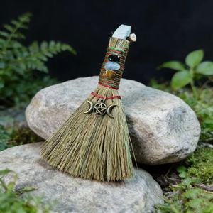 Detailed view of handmade witch besom with natural crystals and pentagram moon charm