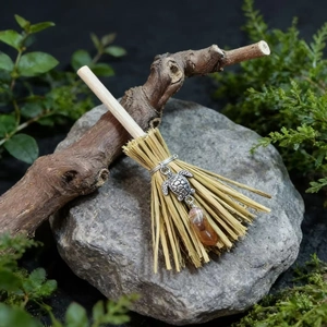 Detail of miniature witch broom featuring silver sea turtle and amber crystal pendant