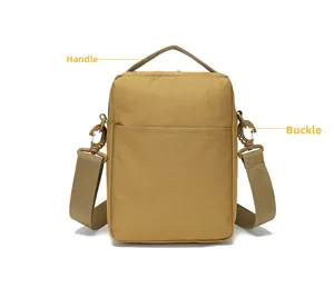 Detail view of khaki tactical bag featuring a top handle and durable plastic buckles