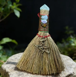 Close-up of witch broom ornament with natural crystals and a bronze flying witch charm