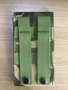 Detailed view of the MOLLE system straps and metal snaps on a tactical camo pouch