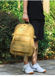 Tactical khaki backpack with MOLLE system and multiple pockets shown in outdoor setting