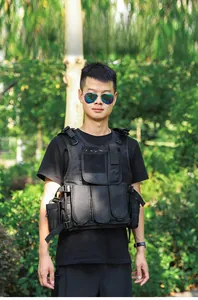 Detail view of durable black tactical vest featuring utility pouches and velcro straps
