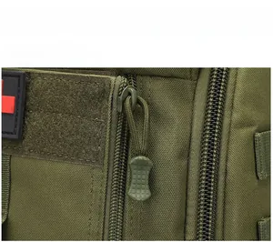 Tactical medical backpack detail showing paracord zipper pulls and red cross patch