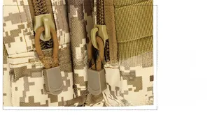 Close-up of tactical waist bag dual zippers with desert camo fabric and paracord pulls