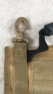 Detail of khaki tactical bag showing heavy-duty nylon webbing and plastic swivel hook