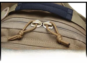 Close-up of durable dual zipper pulls and reinforced padded handle on the coyote tactical bag
