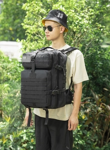 Detail eines schwarzen taktischen Rucksacks mit MOLLE-System und mehreren Staufächern