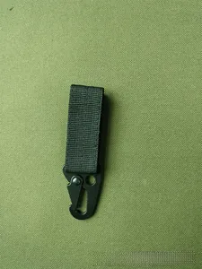 Detail of a tactical nylon webbing strap with a matte black metal carabiner clip