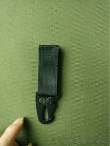 Detail of a tactical black metal eagle hook with heavy-duty nylon MOLLE webbing