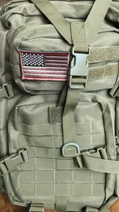 Detailed close-up of tactical tan nylon backpack featuring US flag patch and MOLLE system
