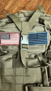 Detailed macro view of khaki tactical backpack featuring Molle webbing and flag patches