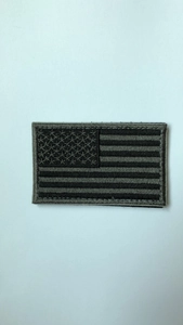 Macro detail of USA flag tactical embroidery patch with gray stitching for outdoor backpacks