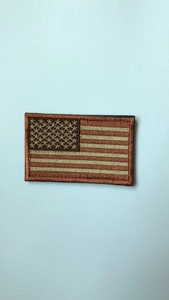 Close-up of tactical US flag embroidery patch with tan stitching for outdoor gear