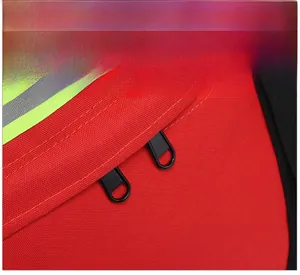 Détail de la bande réfléchissante et des fermetures éclair doubles sur le sac à dos rouge