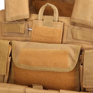 Detail of sand color tactical vest showing reinforced nylon material and MOLLE system straps