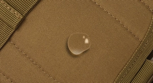 Macro detail of brown tactical fabric showing water-resistant high-density nylon fibers