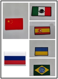 Detalle de parches tácticos de banderas nacionales en PVC con textura 3D en relieve