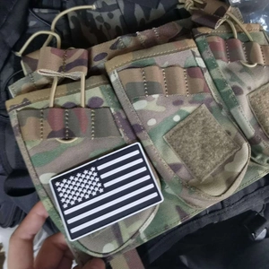 Detalle del parche de PVC de bandera americana en una bolsa táctica camuflada