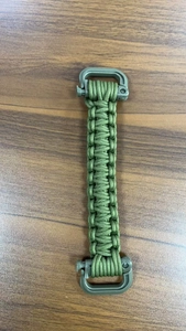 Detail showing the tight military green paracord braid and durable plastic buckles on handle