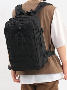 Close-up of black tactical backpack featuring MOLLE webbing system and elastic adjustment cord