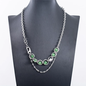 Collier double couche en acier titane avec perles vertes craquelées sur présentoir