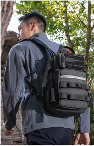 Detail of black tactical backpack with Molle system and orange paracord zipper pulls
