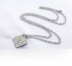 Macro detail of steel Fortune square pendant necklace featuring engraved traditional Fu character