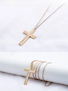 Detalle del collar de cruz en acero inoxidable oro rosa con incrustaciones de cristal fino