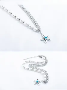 Macro detail of pearl chain necklace with blue gemstone flower pendant on white background