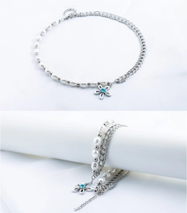 Macro detail of the pearl necklace with a flower pendant and a blue gemstone center