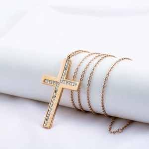 Collar de cruz de acero inoxidable oro rosa con circonitas sobre tela de seda blanca