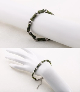 Detailed view of dark green bamboo joint beads and silver steel spheres on the beaded bracelet