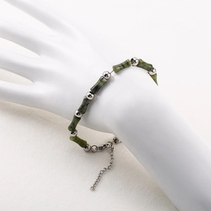 Handmade men's stainless steel bamboo bracelet with dark green beads on a white model hand