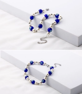 Detail of evil eye beaded bracelet with faux pearls and titanium steel chain for women
