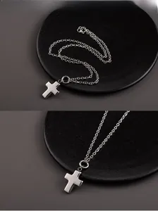 Detailed view of mirror-polished silver 3D hollow cross pendant on a stainless steel chain