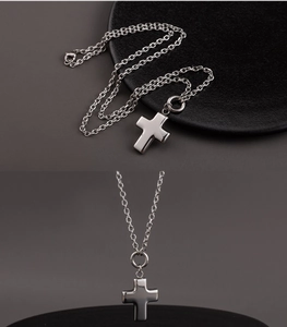 Detailed macro view of 3D hollow cross pendant in silver stainless steel on black stand