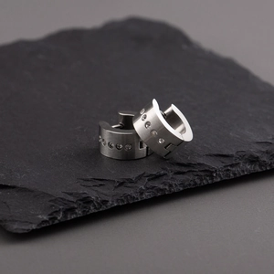 Mens silver matte titanium steel hoop earrings with cubic zirconia on black rock