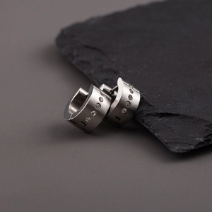 Minimalist matte titanium steel hoop earrings with sparkling diamonds on dark stone