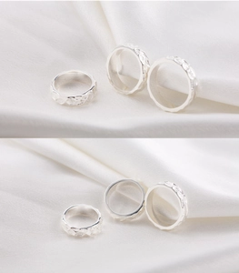 Detail of silver rings featuring irregular hammered textures on a white silk background