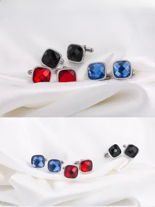 Detailed view of square men's cufflinks set in red, blue, and black with silk background