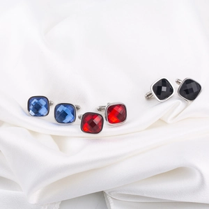 Square stainless steel cufflinks set with colorful rhinestones on white silk background