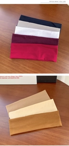 Detailed pile of elastic athletic headbands in various solid colors on a wooden surface