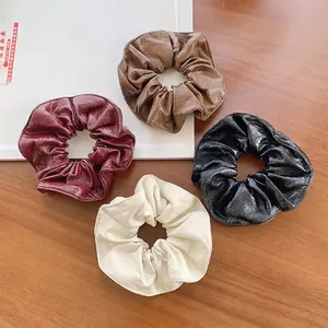 Set of four vintage faux leather scrunchies in brown, burgundy, cream, and black colors