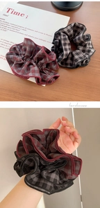 Close-up of red and grey plaid oversized scrunchies showing fabric texture and ruffles