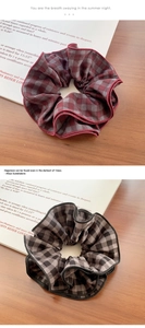 Close-up of vintage plaid scrunchies with delicate ruffled edges on wooden desk