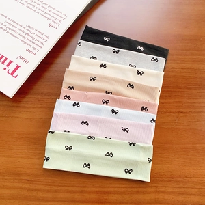 Lot de 8 bandeaux en tricot côtelé coloré avec motif nœud sur fond en bois