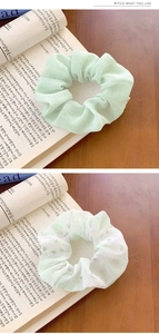 Detail of floral and mint green hair scrunchies on a rustic wooden background