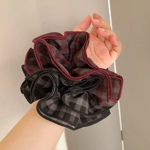 Retro oversized plaid scrunchie with ruffled edges in burgundy and grey on wrist
